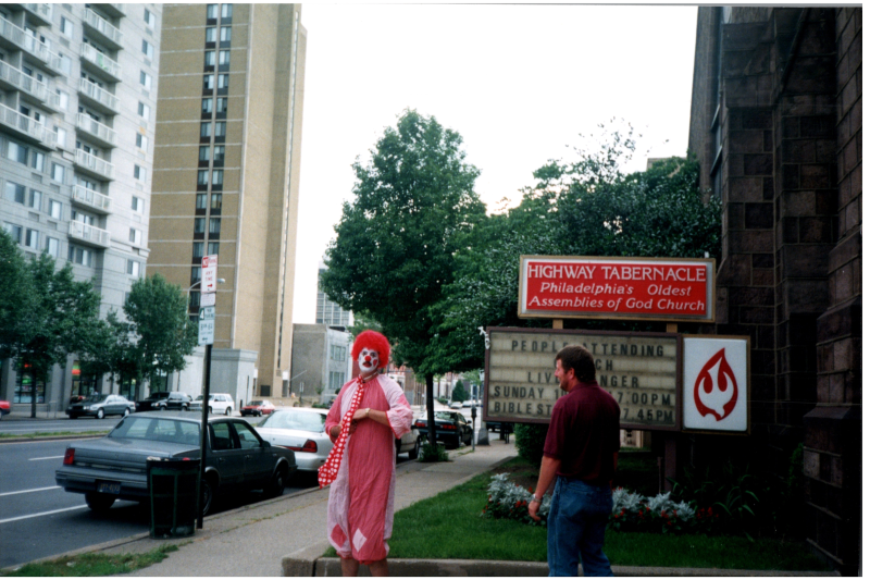 Lloyd and Harvey, one dressed as a clown outside of the church