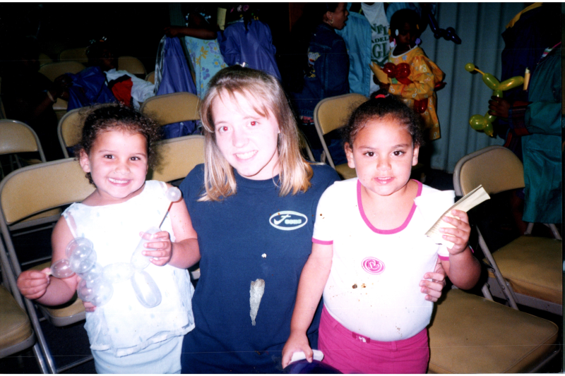 Ashley with two children, one holding a balloon animal