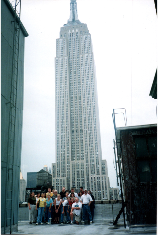A group smiles in front of a building