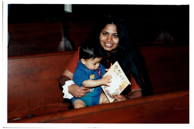 Cizely Kurian holding a baby on a pew