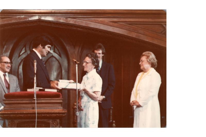 A man presents an older woman with a present