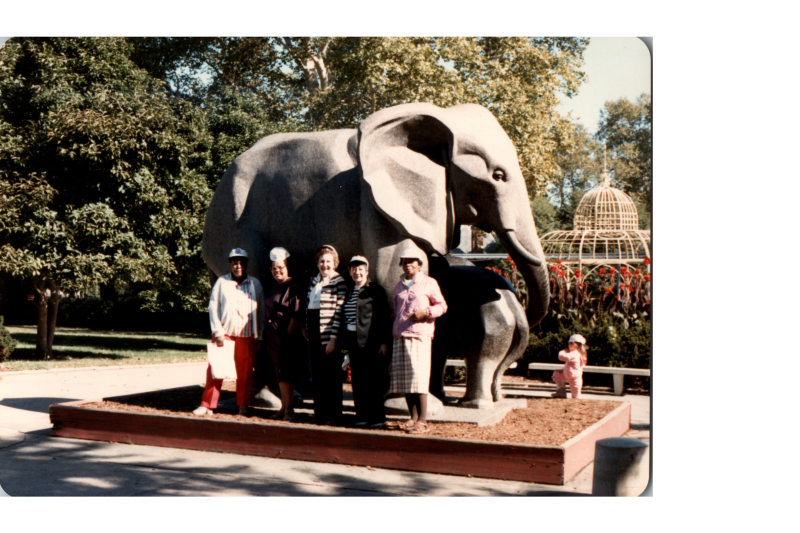 A group poses for a photograph with an elephant statue