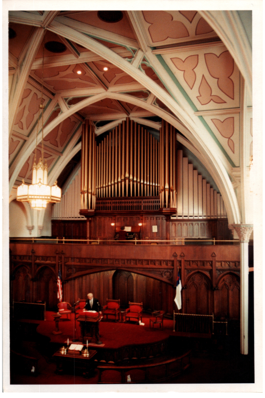 Image of the sanctuary at 18th and Spring Garden Street with a man at the pulpit