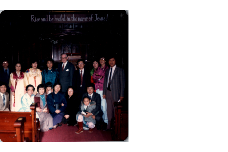 A group smiles for a portrait in the sanctuary with text reading, "Rise and be healed in the name of Jesus!"