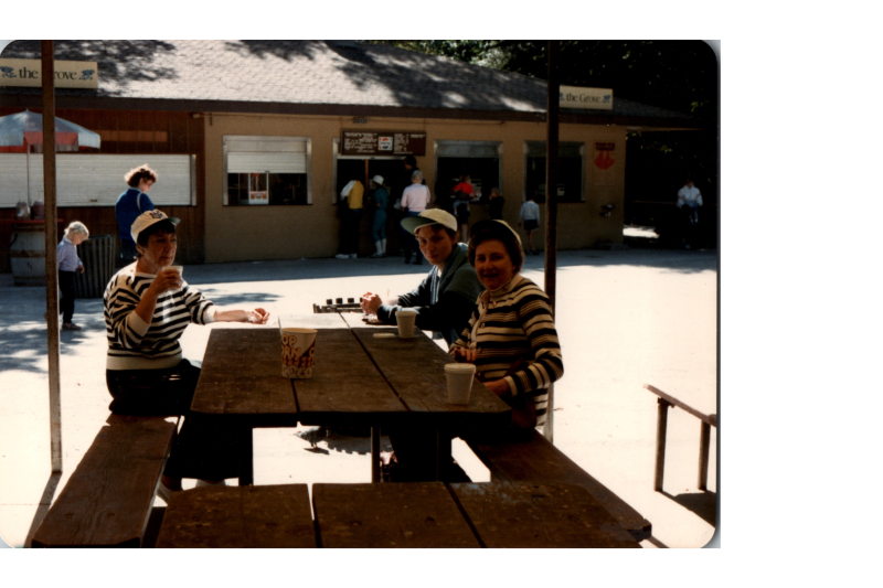 A group smiles together around a picnic table