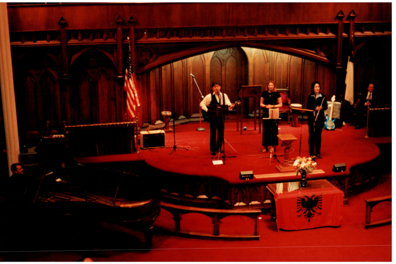 Music performance in front of an Albanian flag in the sanctuary