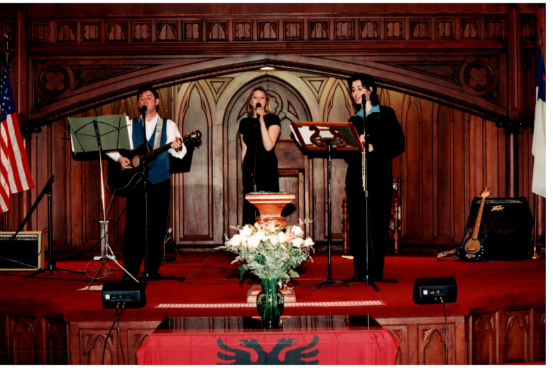 Music performance in front of an Albanian flag in the sanctuary