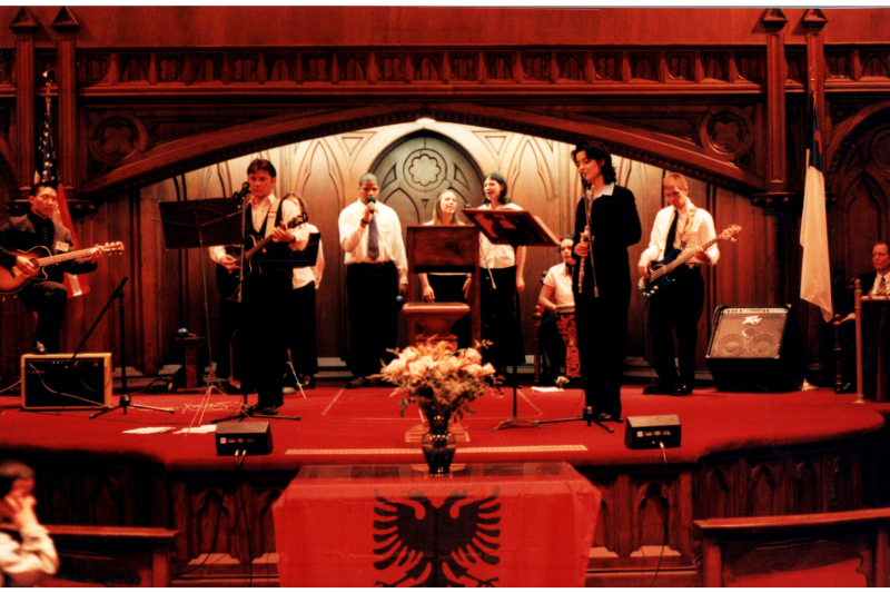 Music performance in front of an Albanian flag in the sanctuary