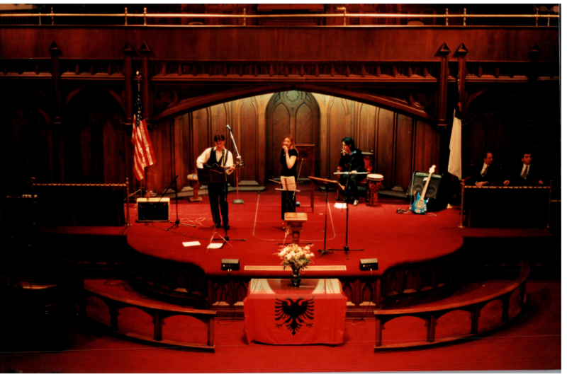 Music performance in front of an Albanian flag in the sanctuary