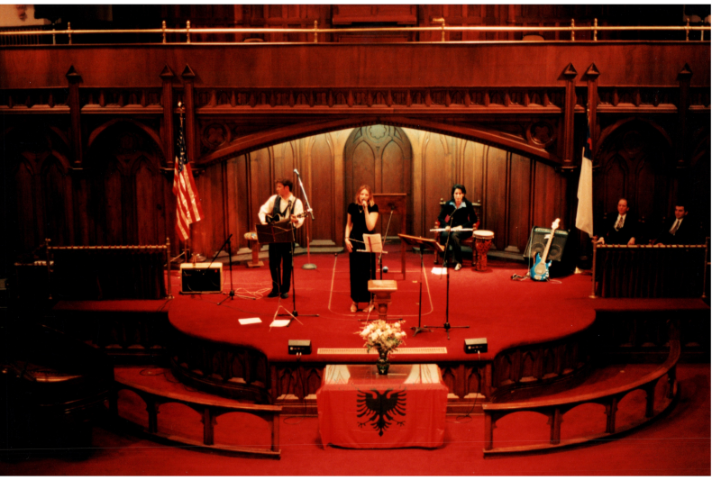 Music performance in front of an Albanian flag in the sanctuary