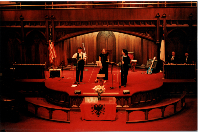 Music performance in front of an Albanian flag in the sanctuary