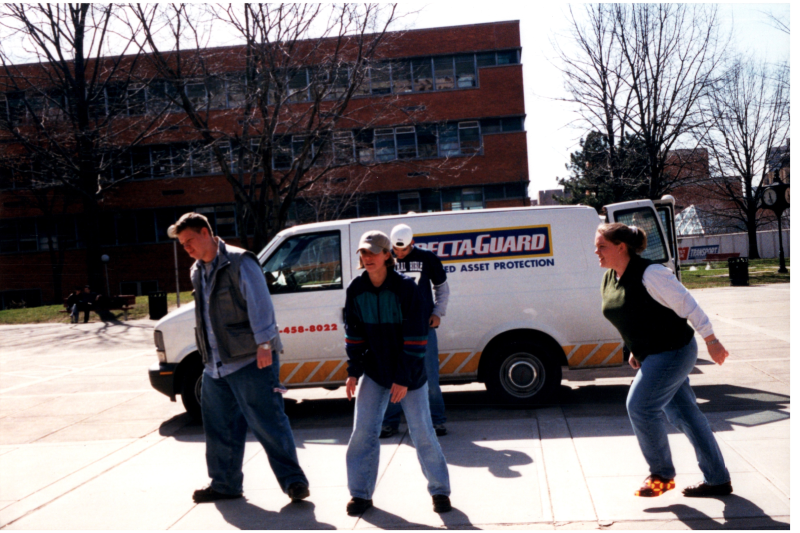 A group walks by a Specta-Guard Van