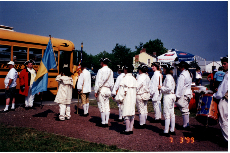 A historical reenactment next to a yellow school bus