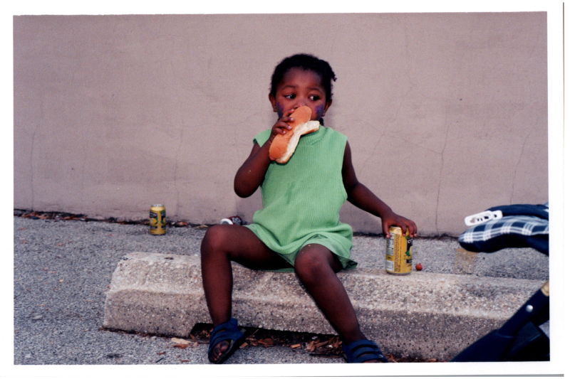 A girl eats a hotdog
