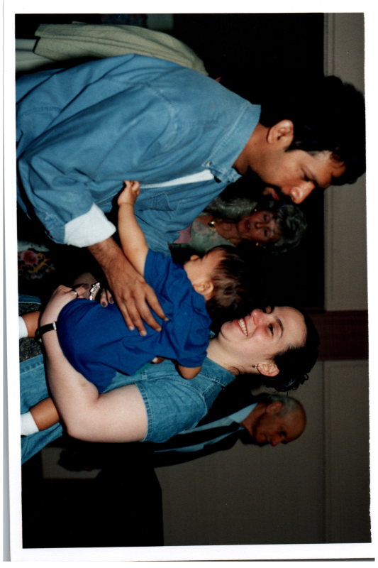 A woman hands a man a baby