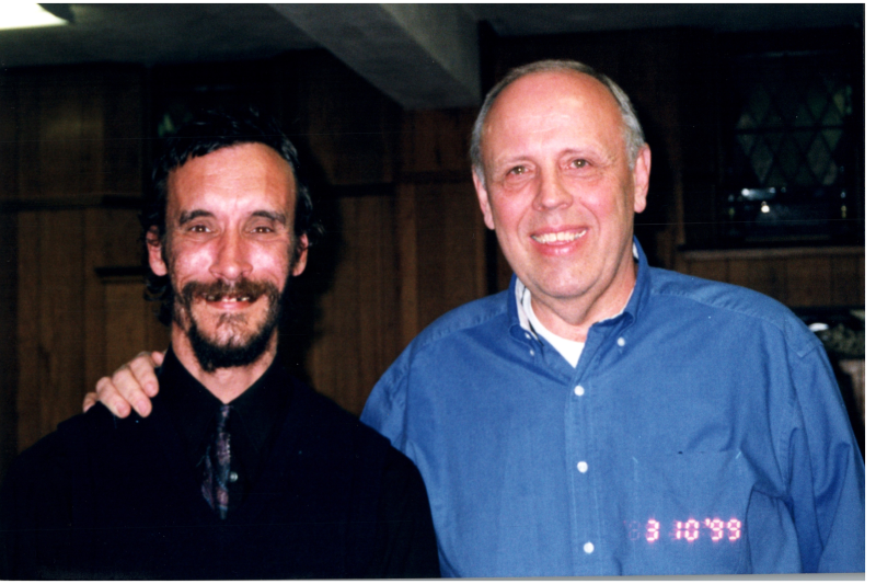 Two men smile together