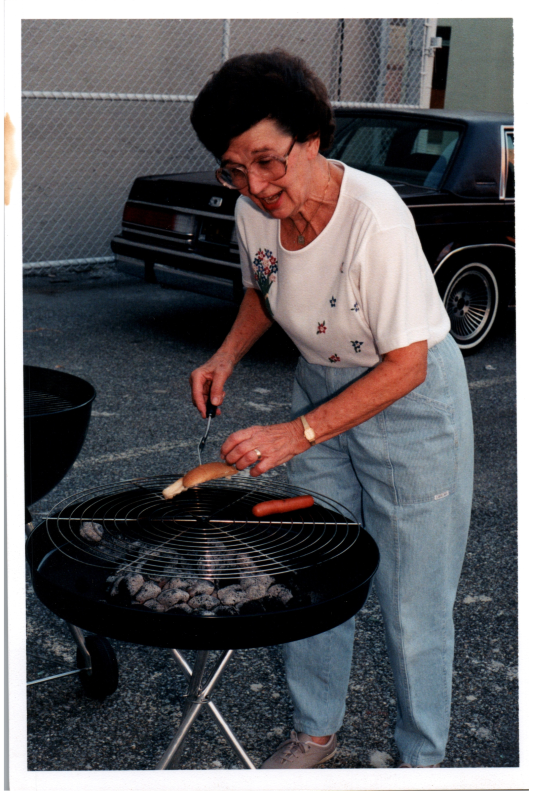 A woman cooks hotdogs