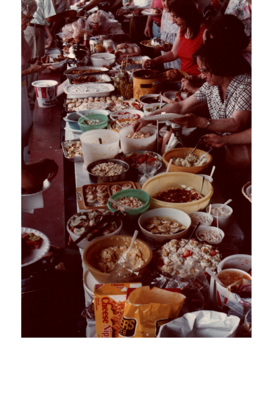 People serve themselves from a spread of food