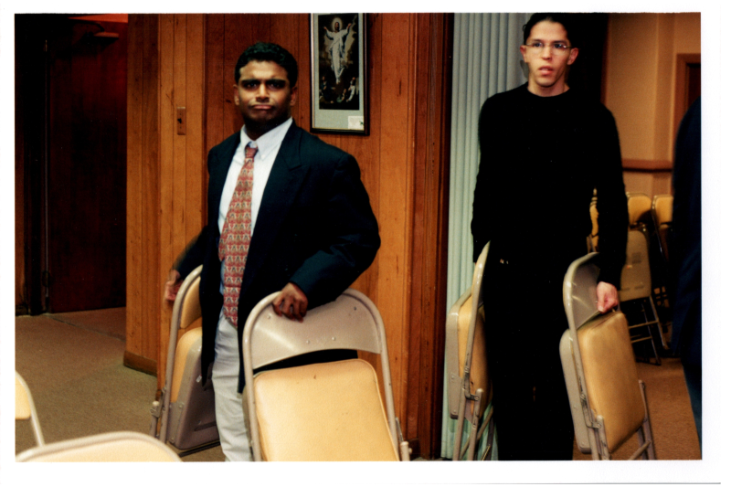 Pastor Kurruvilla and others carry chairs