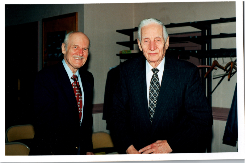 Two men smile together