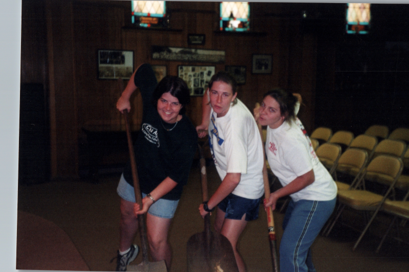 Three women poses with shovels
