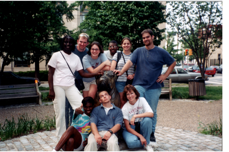 A group poses with a dog statue