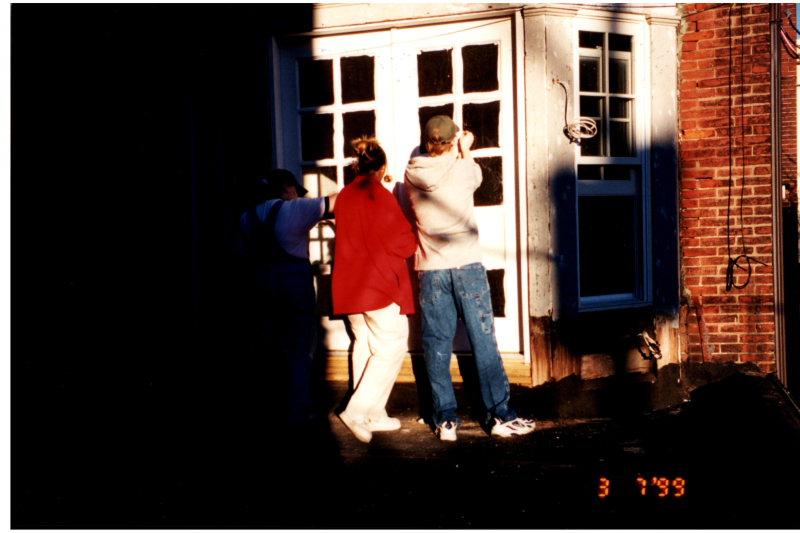 A group paints the parsonnage's exterior
