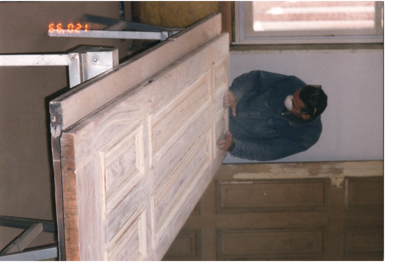 Man sands a door