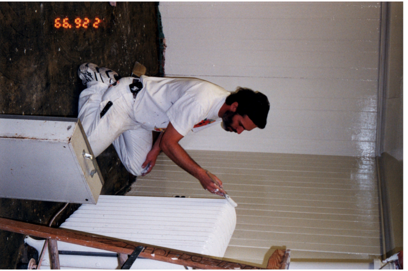 A man paints a radiator