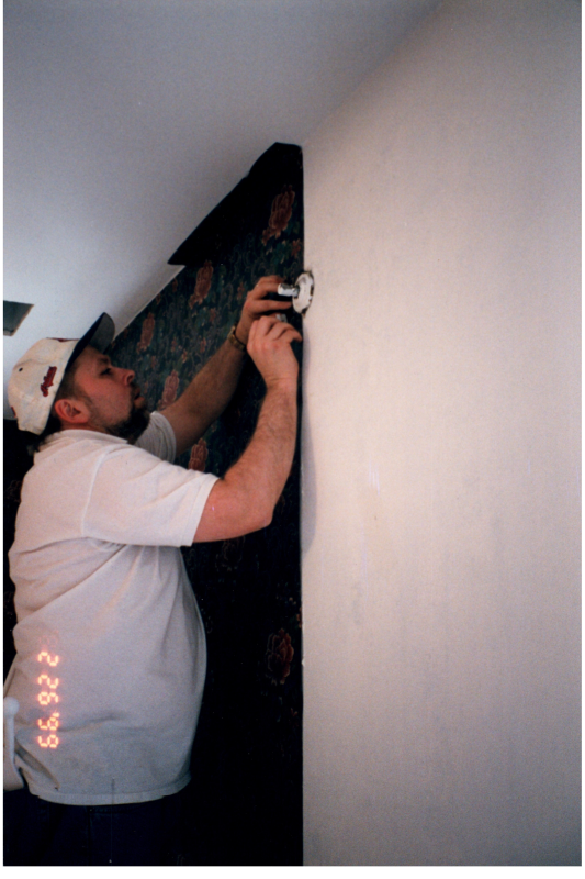 Man hangs wallpaper