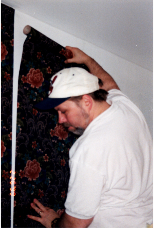 Man hangs wallpaper