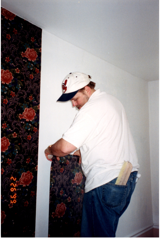 Man hangs wallpaper