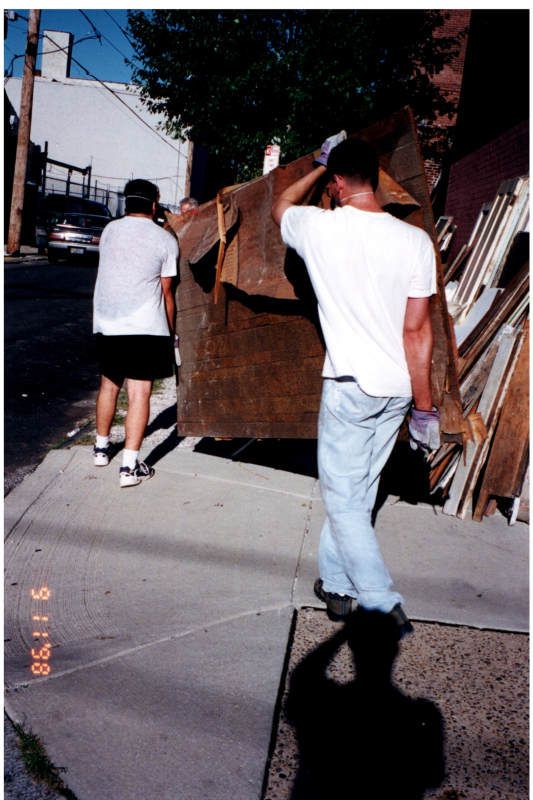 Men carry a slab of wood