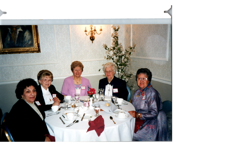 A group of older women eat together