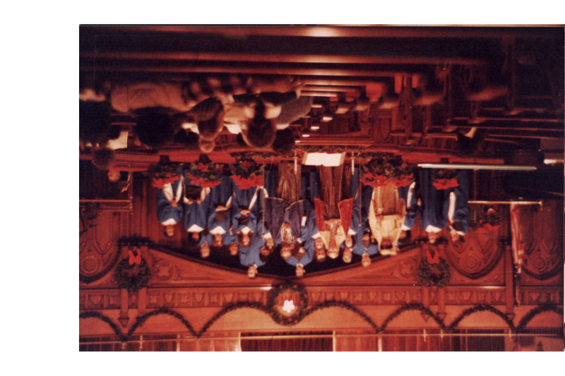 Adults sing as a choir with people dressed as the three wise men