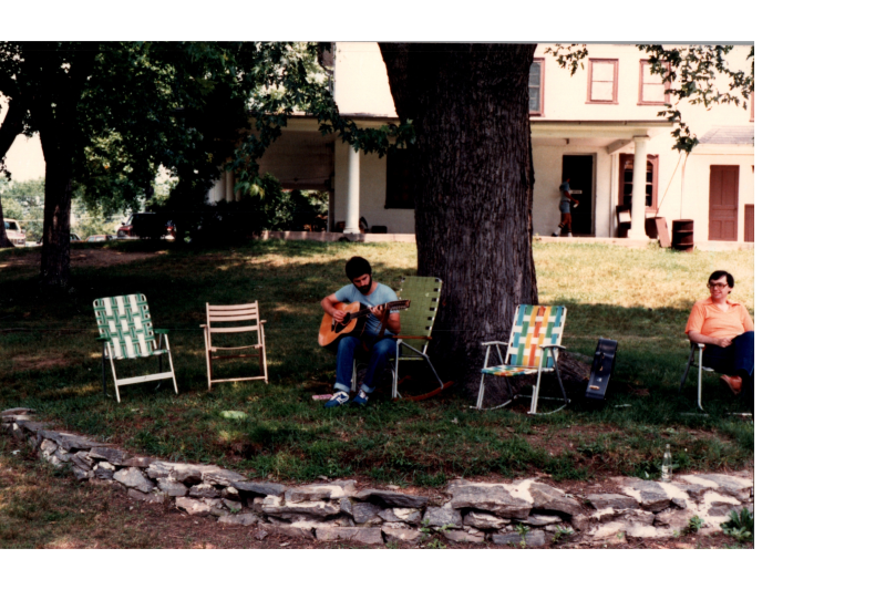 A man plays guitar in a lawn chair