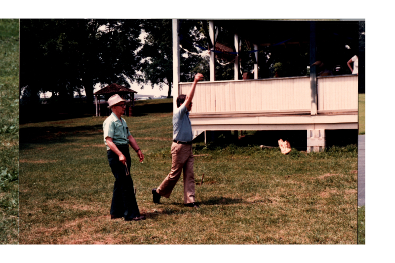 Men throw horseshoes