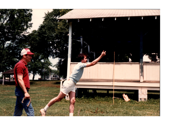 Men throw horseshoes