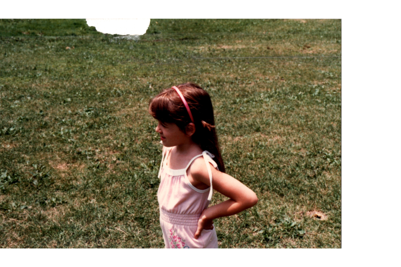 A young girl stands in a field