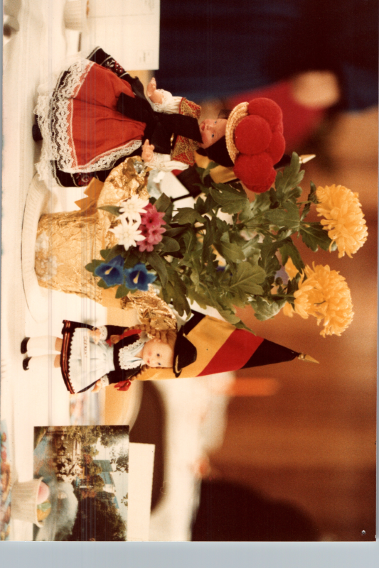 German dolls and a flag are displayed with flowers