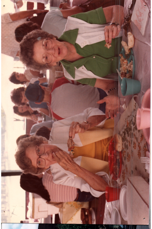 Women eat together in a pavillion