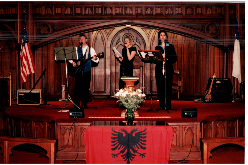 Music performance in front of an Albanian flag in the sanctuary