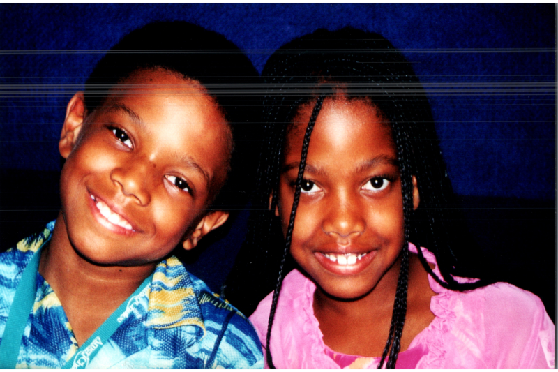 A boy and girl smile for a portrait