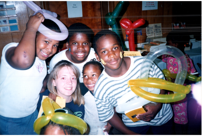 A woman with kids and balloon animals