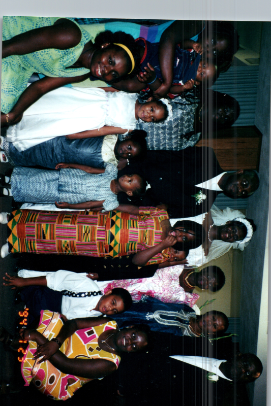 A group smiles with a bride and groom