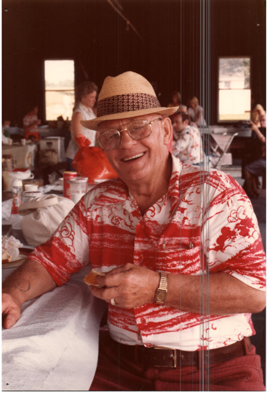 A man smiles under a pavillion