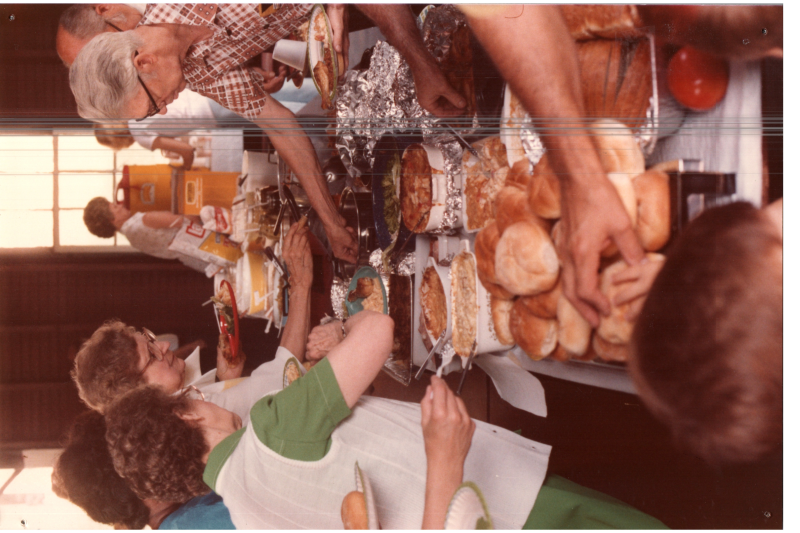 Congregants grab food from a spread