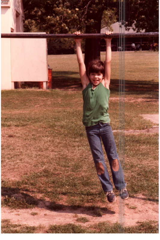 A girl hangs from a pole