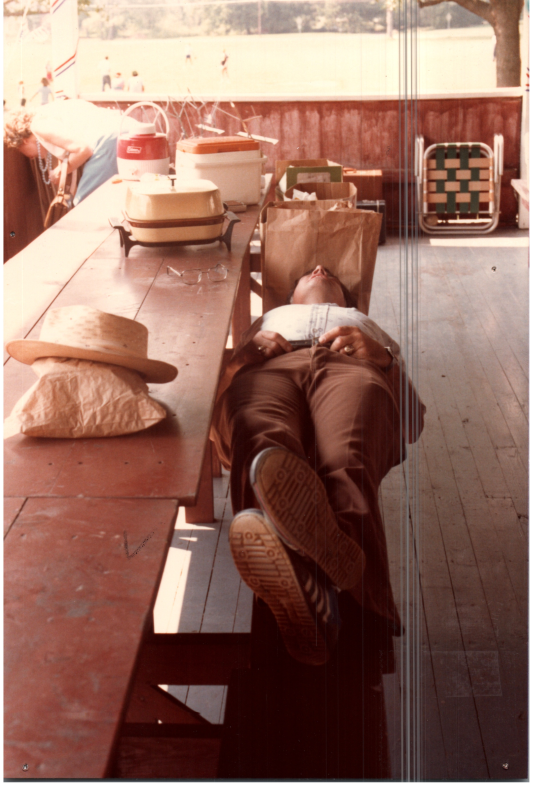 A man naps on a picnic table
