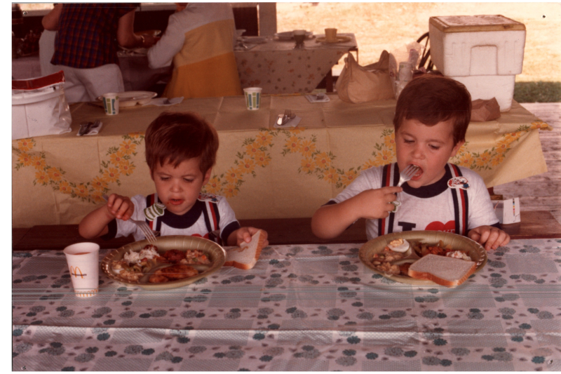 Two boys eat in the pavillion